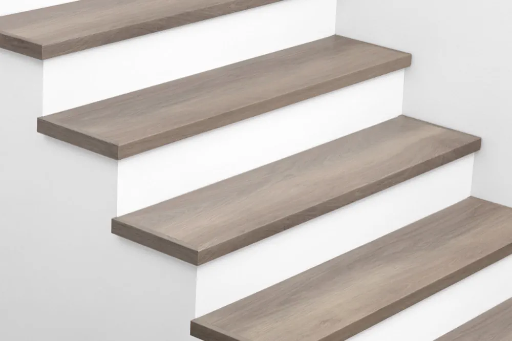 View from above of Urban Surfaces' All-In-One SPC Stair Treads installed on a staircase. Color is 2908 Whispering Pines from the T Molding product line.2908 Whispering Pines