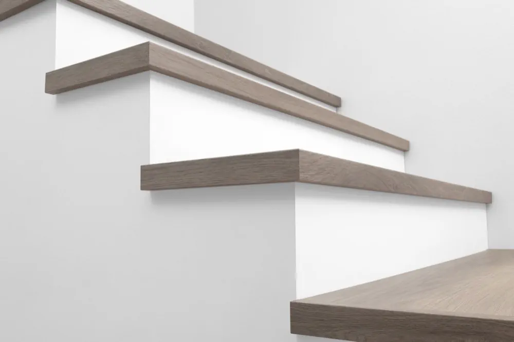 View from below of Urban Surfaces' All-In-One SPC Stair Treads installed on a staircase. Color is 2908 Whispering Pines from the Studio 12 FF product line.2908 Whispering Pines