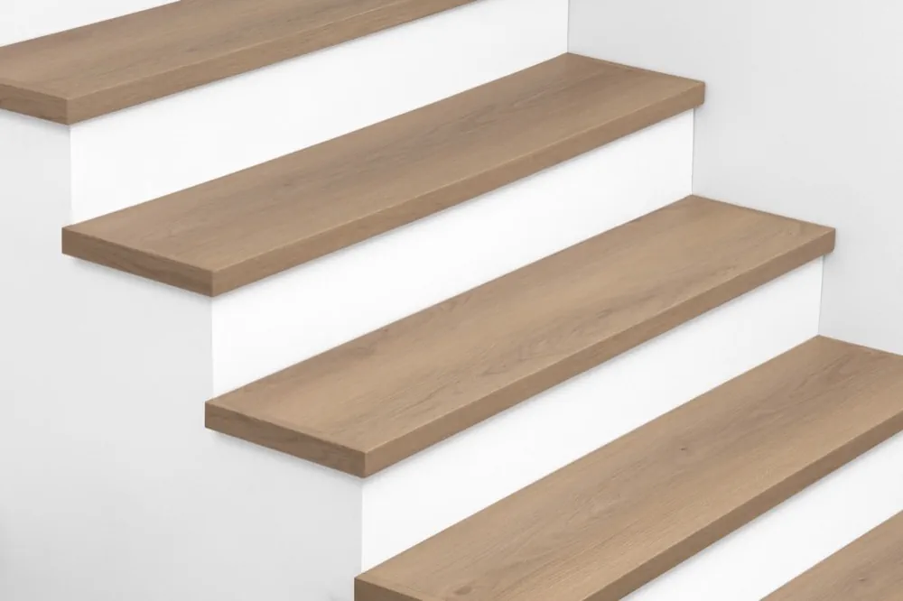 View from above of Urban Surfaces' All-In-One SPC Stair Treads installed on a staircase. Color is 2909 Sandpiper Spring from the Studio 12 SPC Vietnam product line.2909 Sandpiper Spring